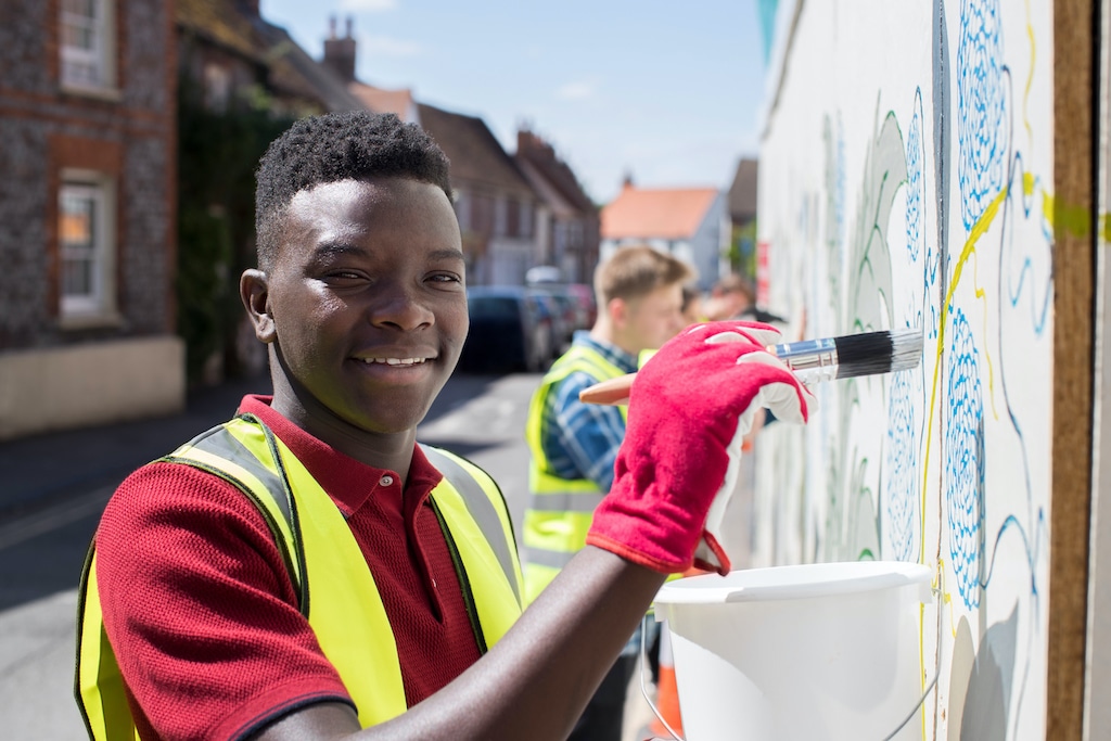 Home page image features a young man painting a wall, showcasing DVULI's resources for urban youth leaders.