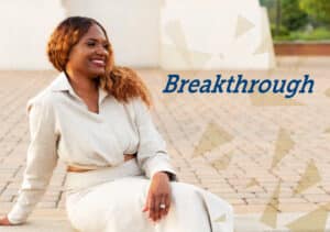 A woman sitting on the ground with the words "breakthrough" - Tammy Barnett achieved balance and accountability through DVULI.