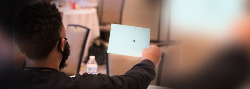 A man holding a tablet attends the DVULI Second National Conference 2021, guided by youth leaders.