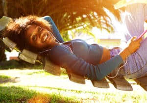 A young woman relaxing in a hammock, practicing self-care and soul-care by Archie Honrado, offering spiritual direction.