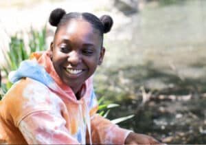 A powerful image of a young black woman in a tie dye hoodie represents empowering youth advocacy.