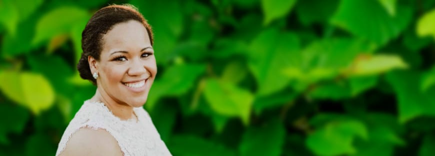 Jessica Taylor, Chief of Staff at Youth for Christ, smiling in front of green leaves. Photo by Will Cumby (Houston 2010).