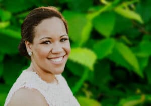 Jessica Taylor, Chief of Staff at Youth for Christ, smiles in front of green leaves. (DVULI alumni)