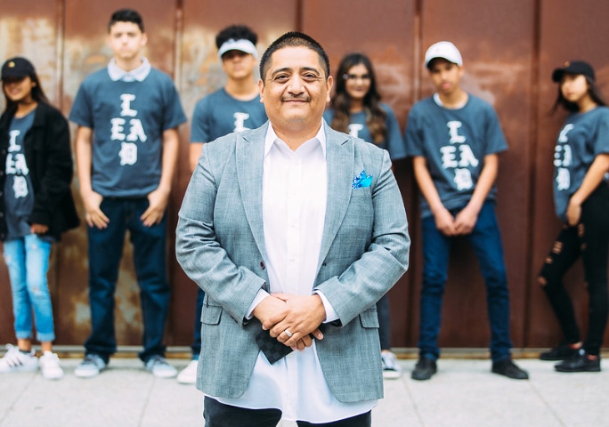 A group of people standing in front of a wall for Tough Talks with Youth by Carlos Nicasio (San Diego 2008).