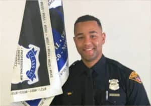 A Cleveland police officer holding a flag: Wesley Reyes graduates from the police academy, fulfilling God's call.