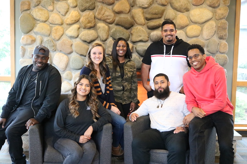 DVULI participants pose in front of a stone wall, showcasing the impact of urban youth leader training.