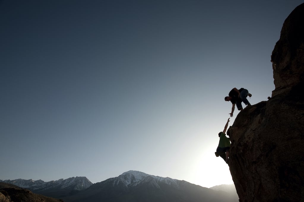 "Two DVULI grads scaling mountains, epitomizing Who We Are, contributing to urban youth development programs."