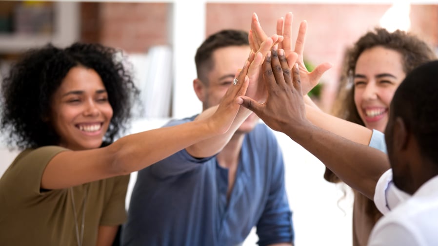 DVULI staff and facilitators attend workshops to enhance understanding of key training modules, giving each other high fives.