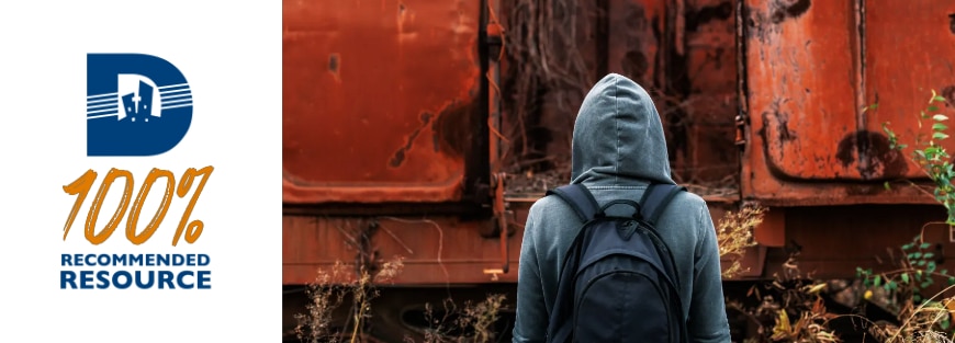 A person in a hoodie standing in front of a train, confronting housing insecurity among urban youth by Brandon Woodard (Cincinnati 2021).