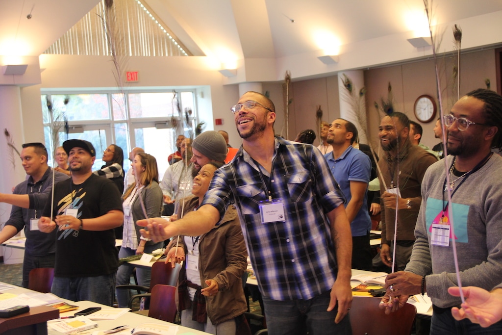 A diverse group of urban youth leaders attend DVULI's community youth development program in a bright room.