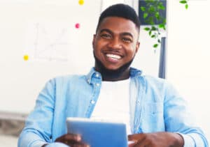 A young African American man using a tablet computer to leverage LinkedIn for urban youth worker training.