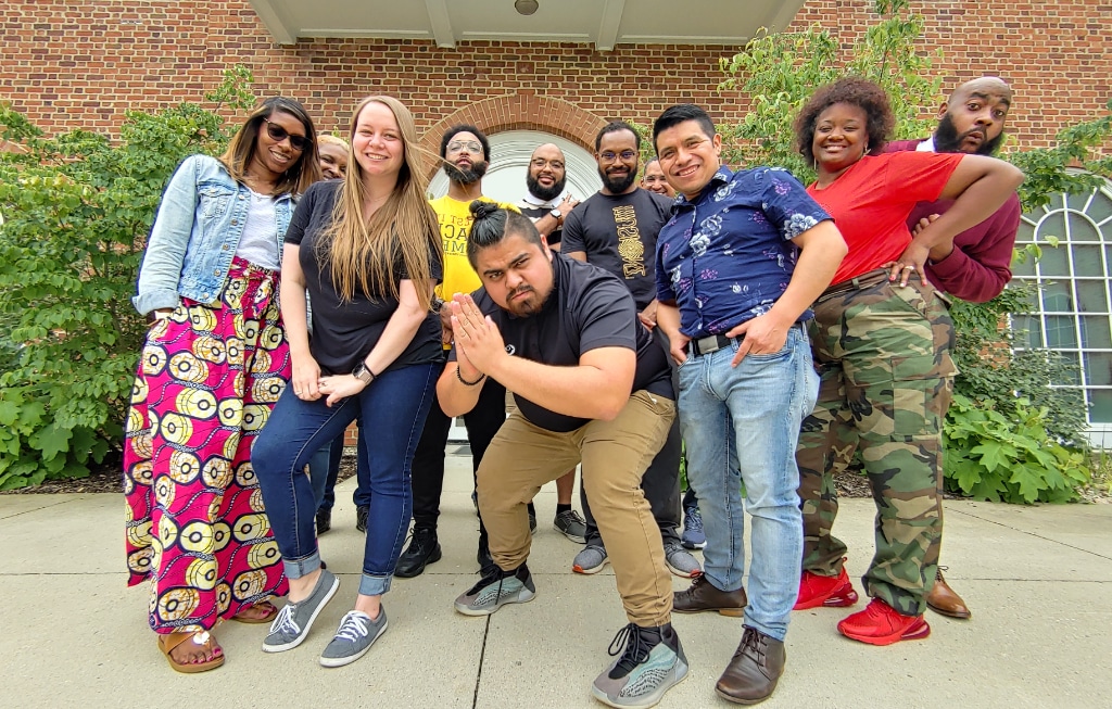 A diverse group of urban youth leaders pose in front of the building after DVULI website registration.